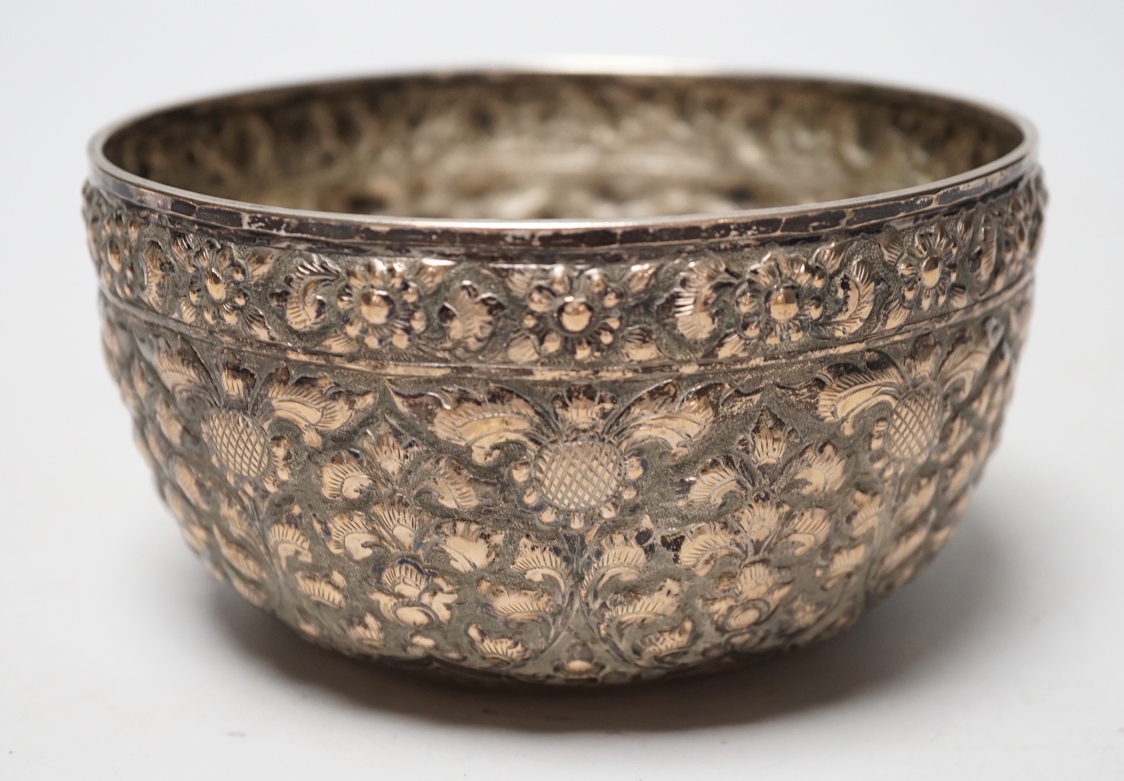 A Chinese Straits? embossed white metal bowl, indistinct marks to the base, diameter 13.9cm, 4.8oz.